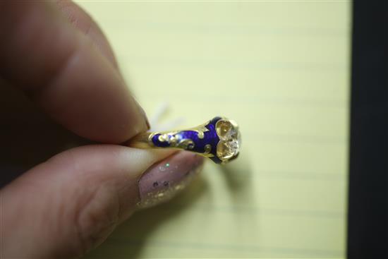 A late Victorian gold, blue enamel and claw set solitaire diamond ring, size P.